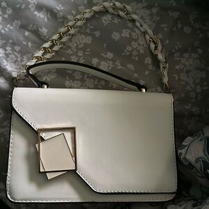 Small white carry on purse with gold accessories